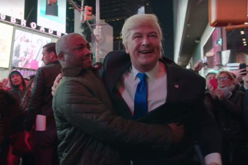 Alec Baldwin hugs a man on the streets of New York City while dressed as Donald Trump.