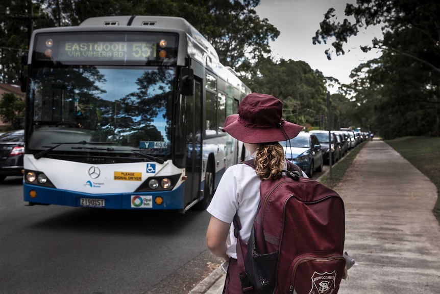 A young girl waiting for a bus