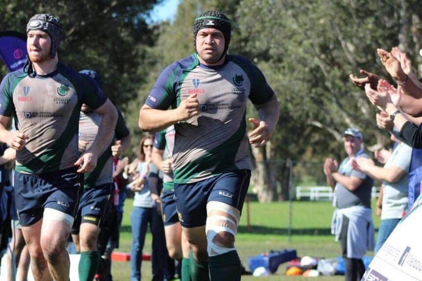 Andrew Fitisemanu running onto the field for his Victorian rugby club