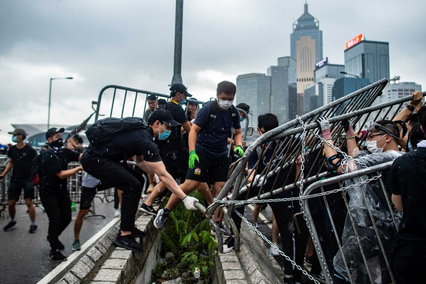香港“反送中”集会上移动路障的抗议人士