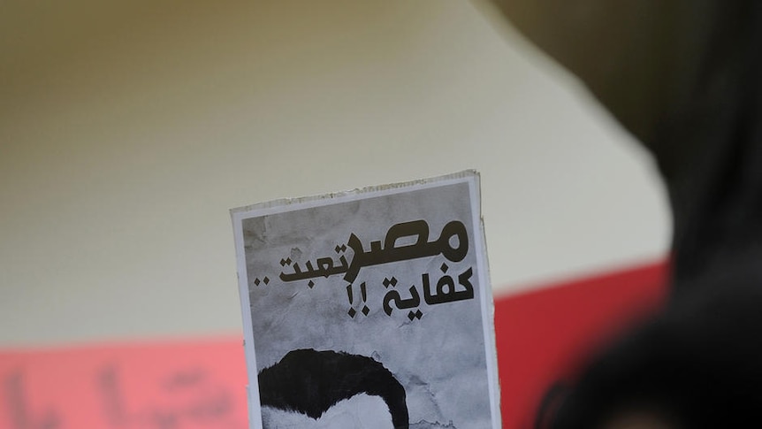 A demonstrator holds a caricature of Egyptian President Hosni Mubarak