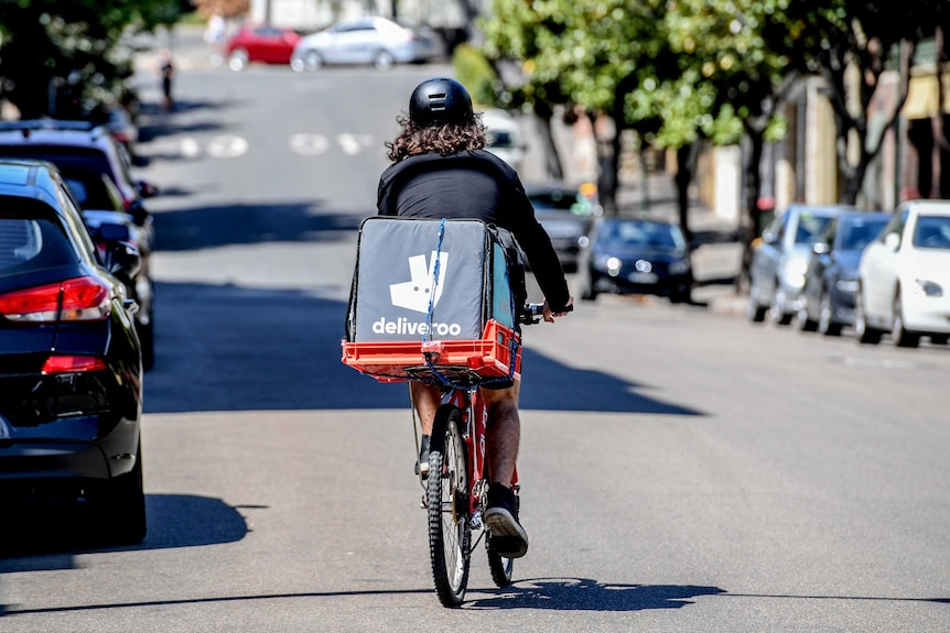 A Deliveroo rider on a bicycle in a suburban Sydney street
