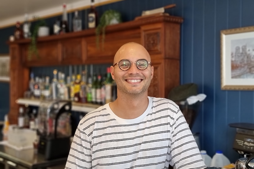 Byron Bay cafe employee Arthur Ferrandez standing at the bar of the cafe he works at.