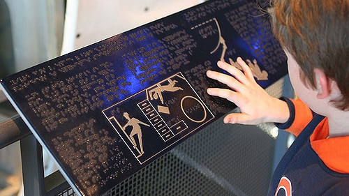 A child with his hand on braille.