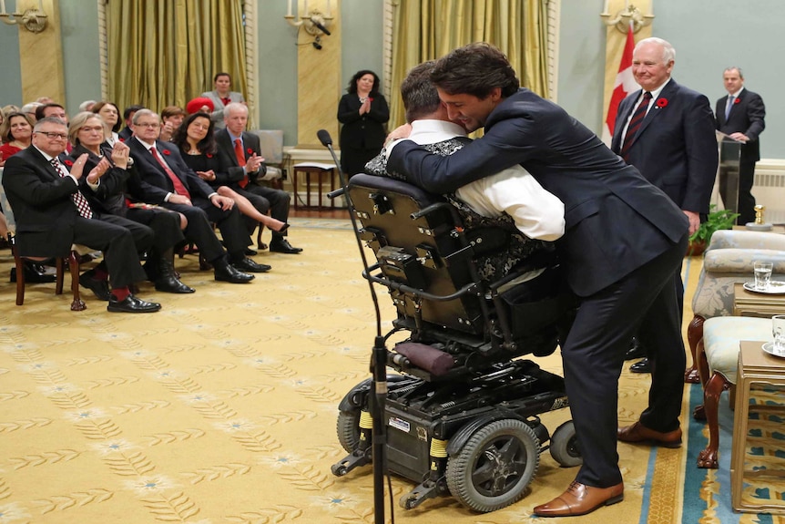 Justin Trudeau hugs new vetrans affairs and associate minister for defence Kent Hehr.