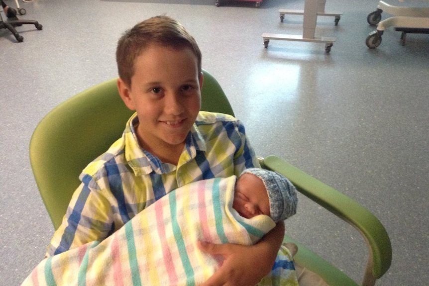 Teenager holding baby