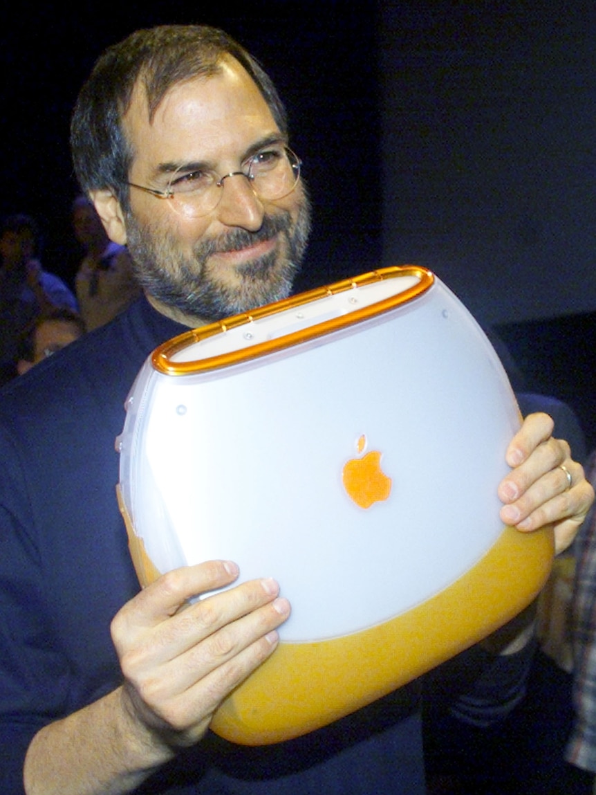 Apple Computer Chief Executive Steve Jobs poses with the company's  iBook portable computer in 1999.