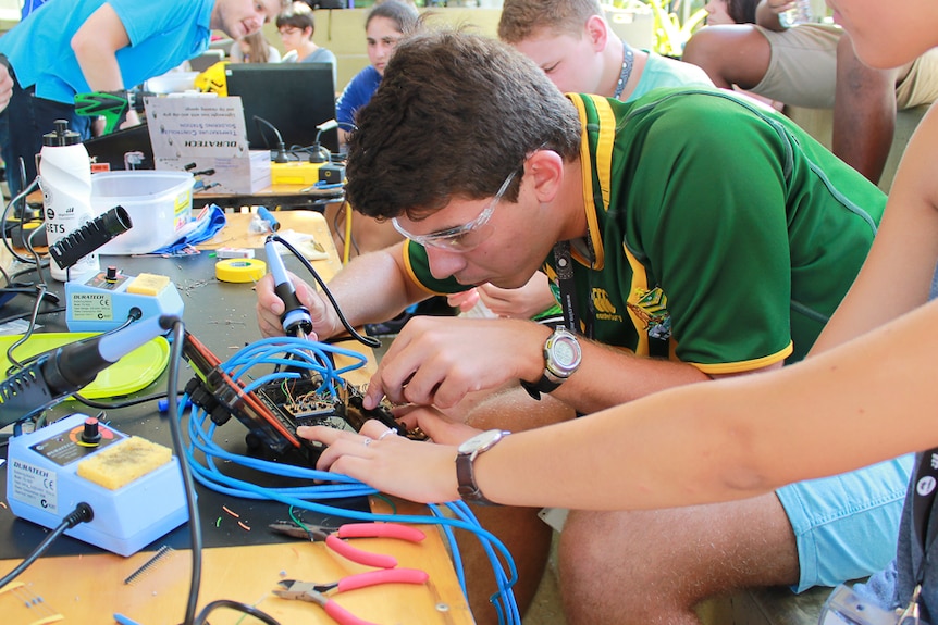 A student solders a battery during a summer school at James Cook University