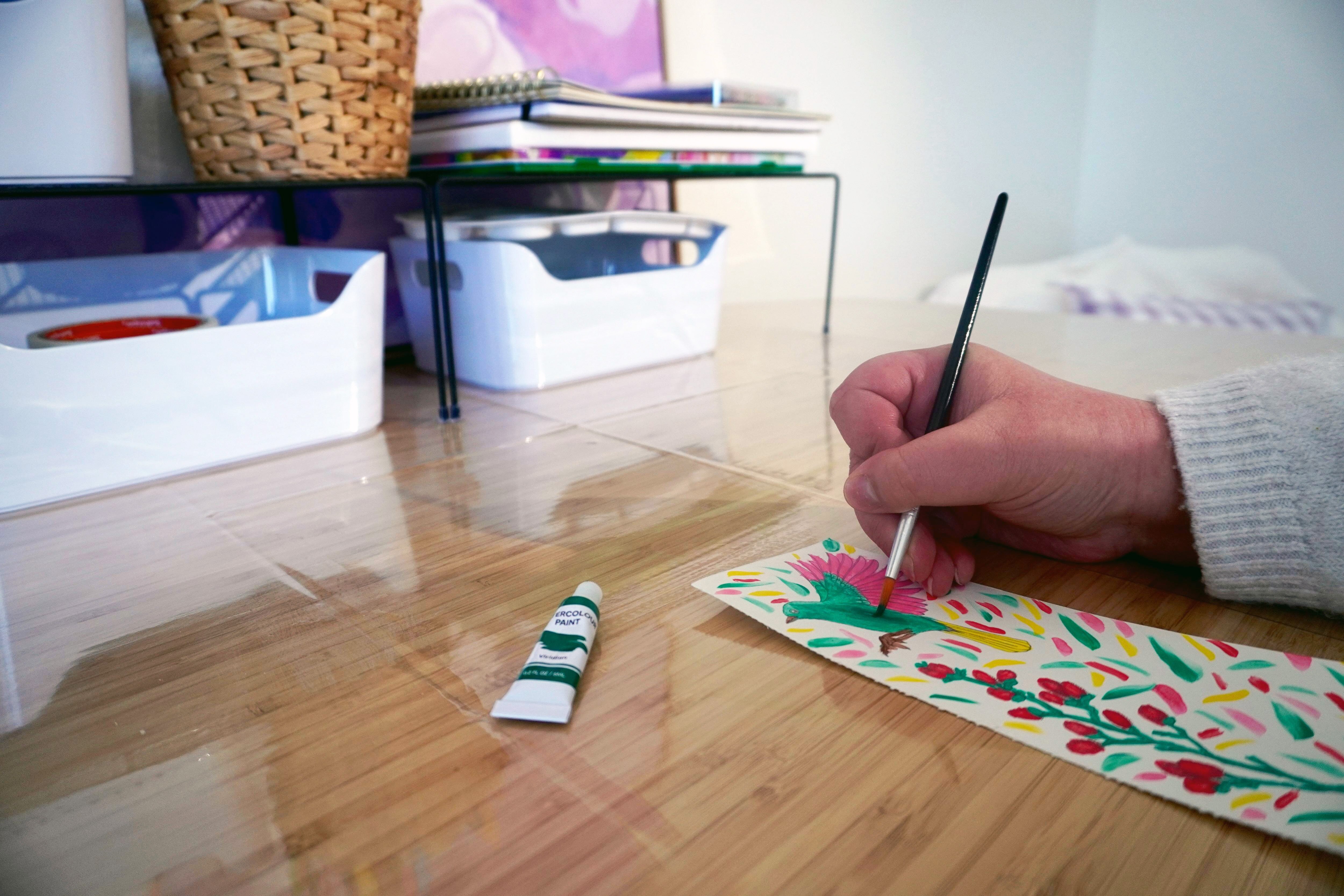 A woman's hand painting a picture.