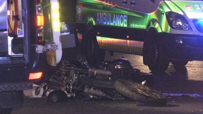 Ambulances surround a crushed motorbike at Bullsbrook, on which two people died