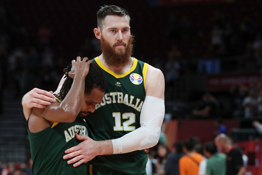 Aron Baynes hugs Boomers teammate Patty Mills during the 2019 basketball World Cup semifinal between Australia and Spain.
