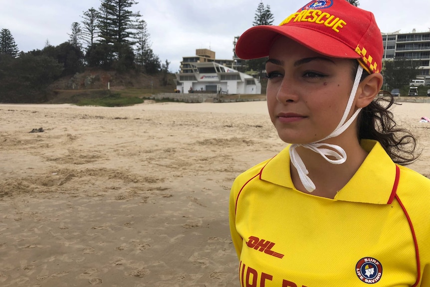 A young woman wearing a surf lifesaving uniform at the beach