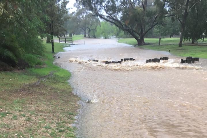 Muddy water flooding a country road