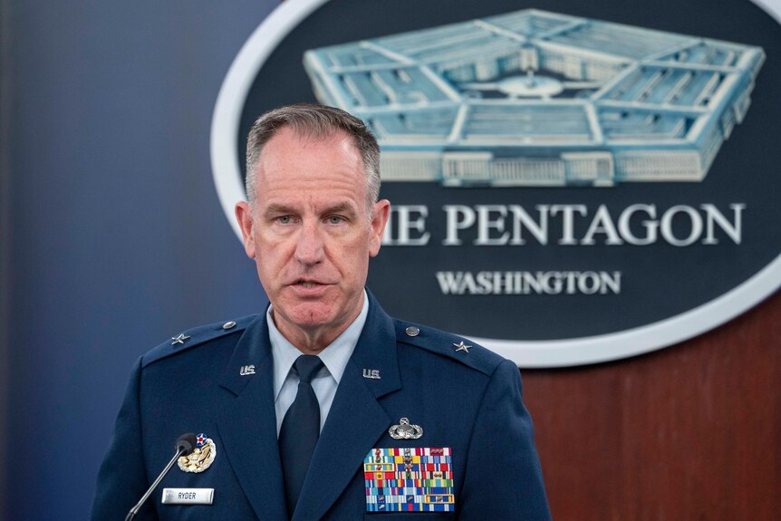 US Brigadier General Pat Ryder in front of a sign that reads "The Pentagon". 