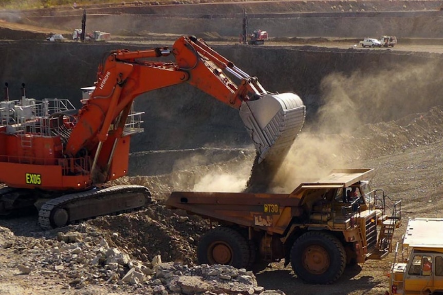 An excavator shovels ore into a dump truck at the Rocklands open pit copper mine in Cloncurry