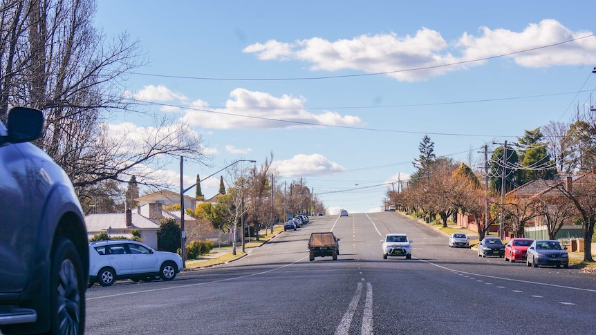 Cars driving down a wide town street