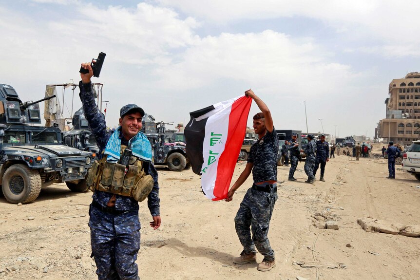 Iraqi Federal Police celebrate in the Old City of Mosul.