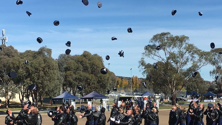 NSW Police cadets throw hats in air at graduation