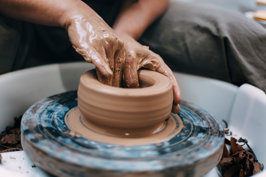 Someone turning clay.