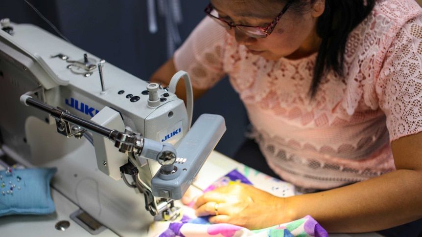 A woman operates a sewing machine.