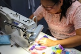 A woman operates a sewing machine.