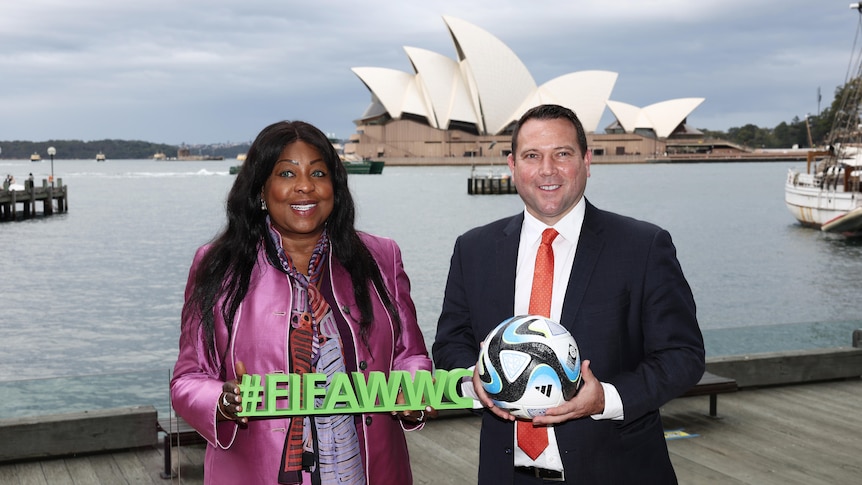 Two soccer administrators pose for a photo outside the Sydney Opera House