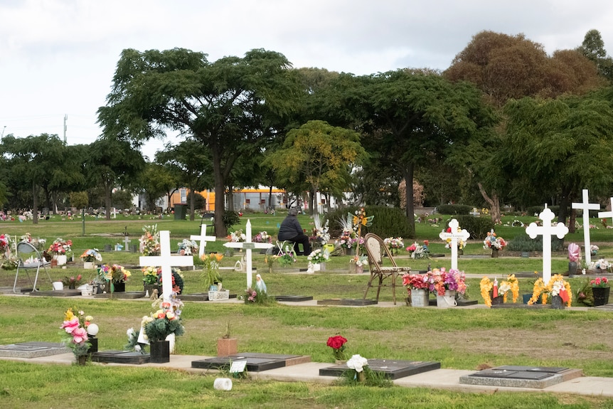 Lady sitting in front of a grave 