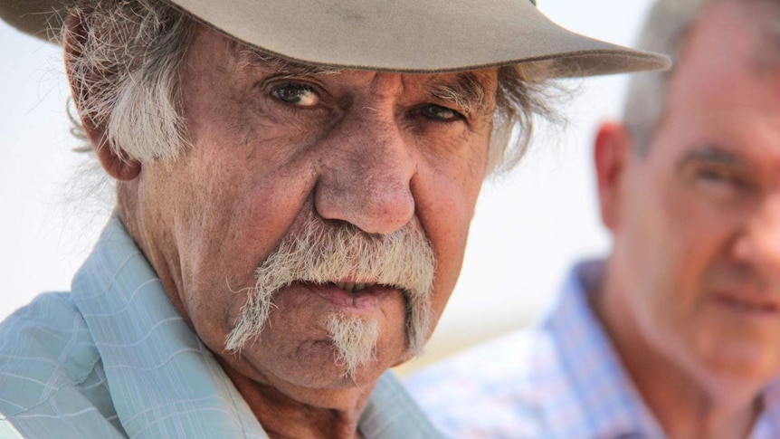 A man with a hat on, looking out of shot.