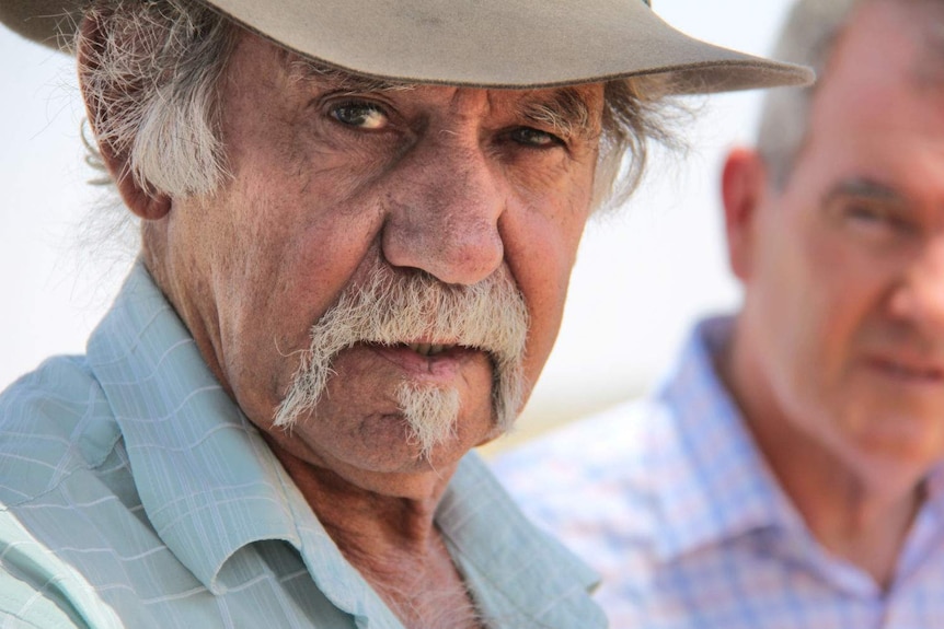 A man with a hat on, looking out of shot.