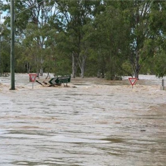 Floodwaters submerge the Lobb St bridge at West Ipswich in south-east Qld