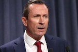 A head and shoulders shot of Mark McGowan speaking at a media conference indoors.