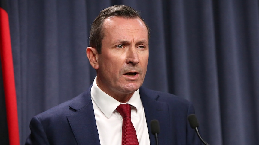 A head and shoulders shot of Mark McGowan speaking at a media conference indoors.