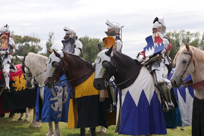 Three knights in silver armor sitting on horses 