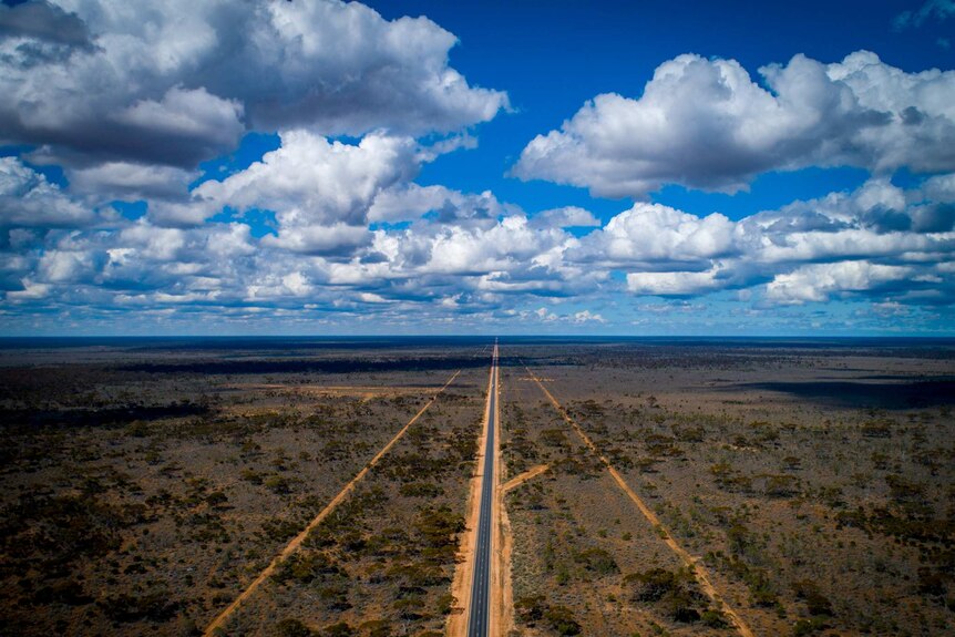 An aerial shot of a dead straight highway in the outback.