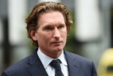 James Hird wearing a suit and tie leaves the Supreme Court.