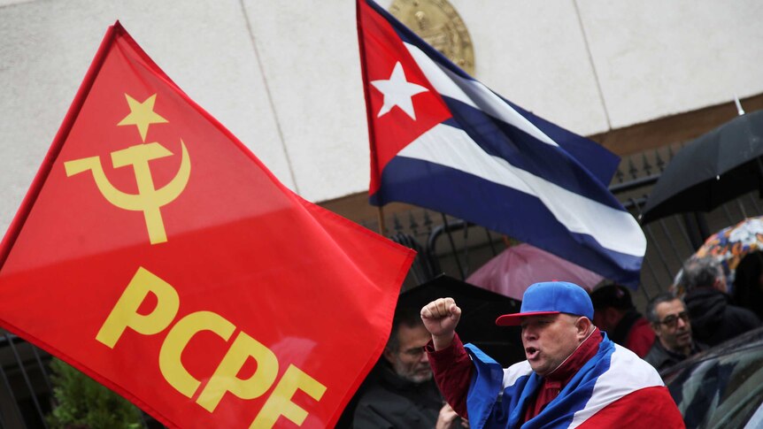 Castro supporters holding the Cuban flag and a Communist Party of the Peoples of Spain flag.