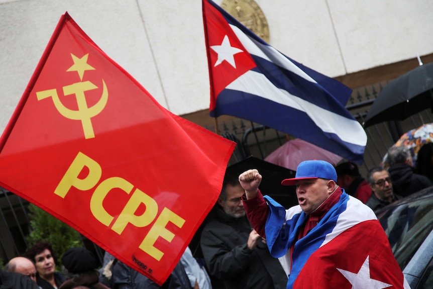 Castro supporters holding the Cuban flag and a Communist Party of the Peoples of Spain flag.
