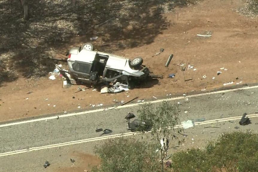 A car flipped on its side on a rural road