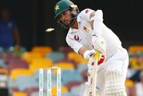 The ball smacks into the off stump, dislodging a bail, as Yasir Shah plays an awkward and unsuccessful shot.