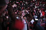 Smiling and waving supporters of presidential candidate Andres Manuel Lopez Obrador celebrate his victory in Mexico City.