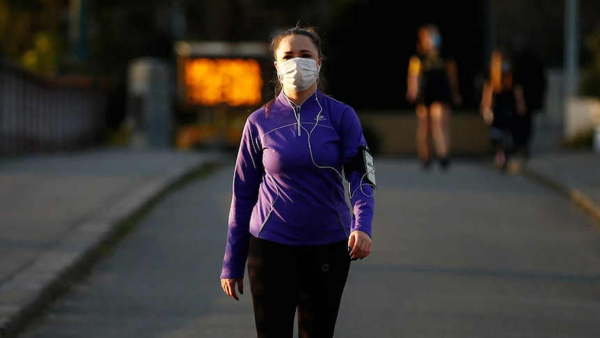 A woman exercising with a mask on in Melbourne.