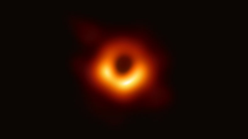 A hazy red-orange ring with a black smudge at its centre.