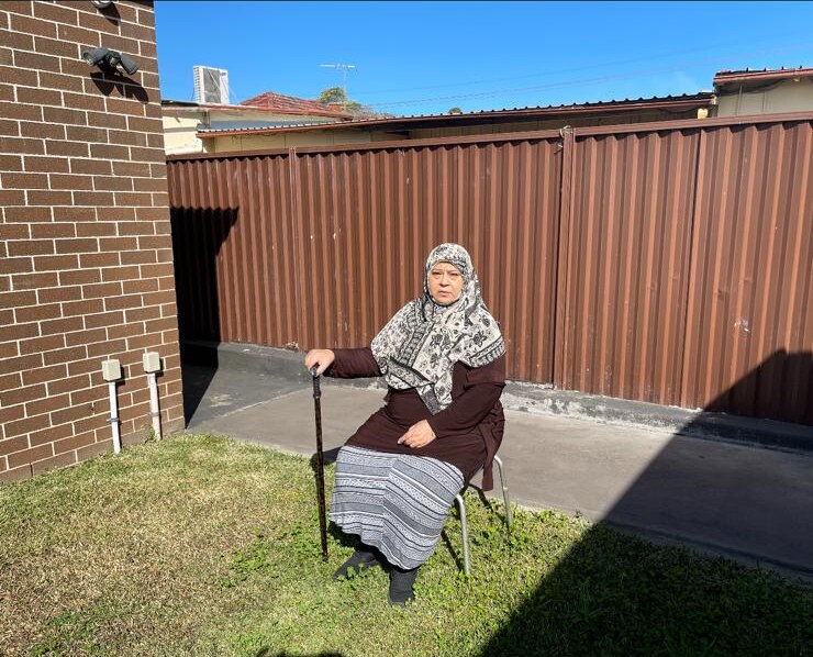 a woman sitting outdoors with her head covered