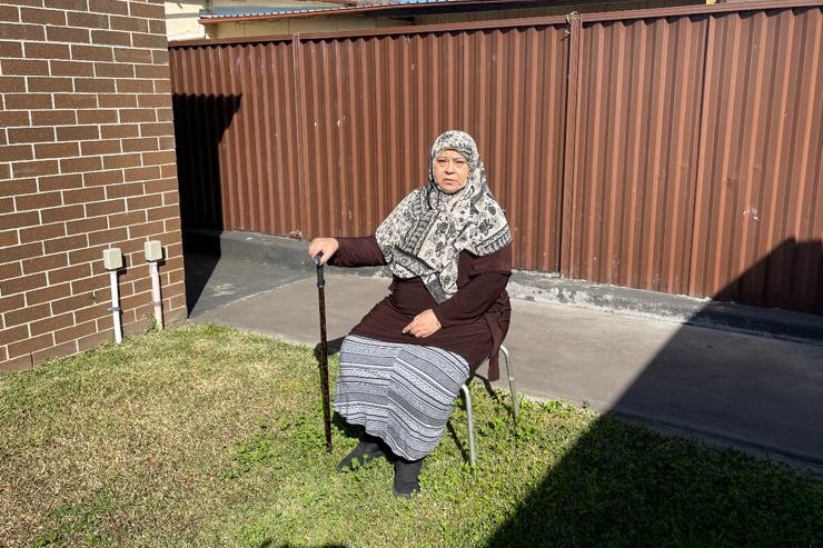 a woman sitting outdoors with her head covered