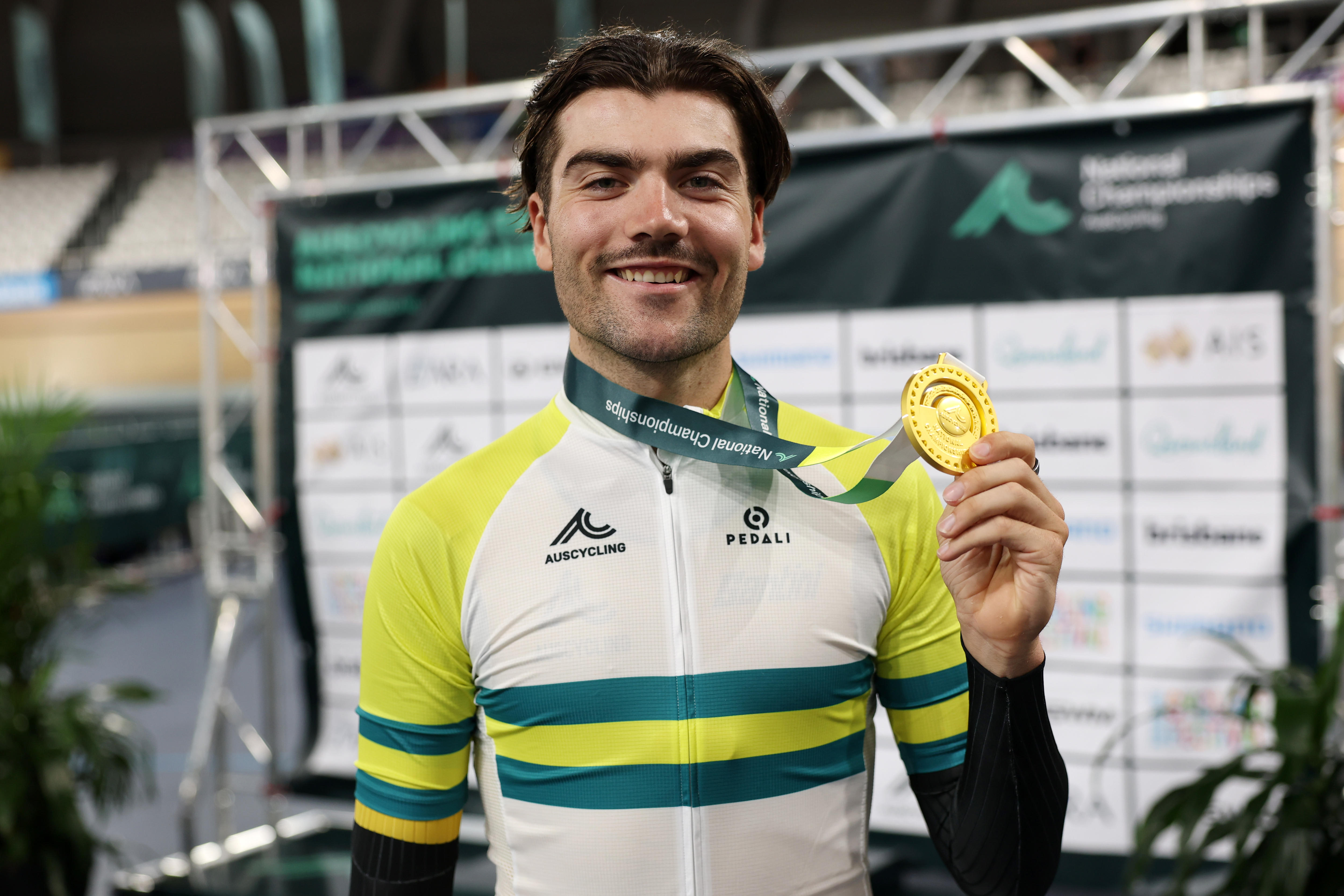 Conor Leahy segura uma medalha de ouro e sorri