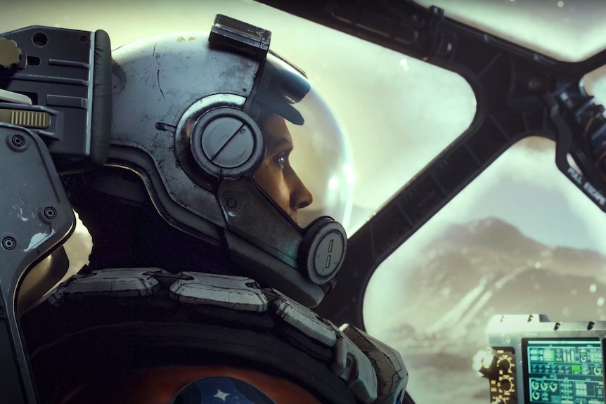 A man wearing a spacesuit in the cockpit of a spaceship stars out of the window.