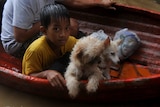 Residents ride a boat as they evacuate a flooded area during typhoon Nesat in San Mateo, Rizal, east of Manila