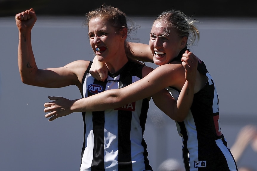 Two Collingwood AFL players celebrate a goal against St Kilda.