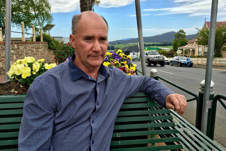 Dorset Council Mayor Greg Howard sits on a park bench.