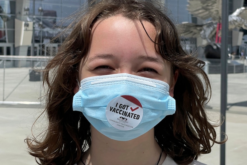 A young American girl smiles after being vaccinated